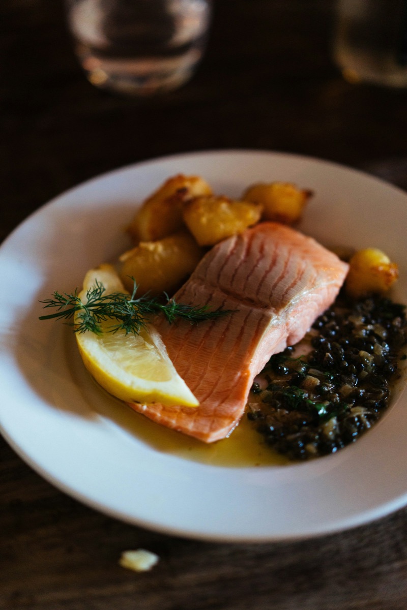 A cooked salmon fillet plated with vegetables