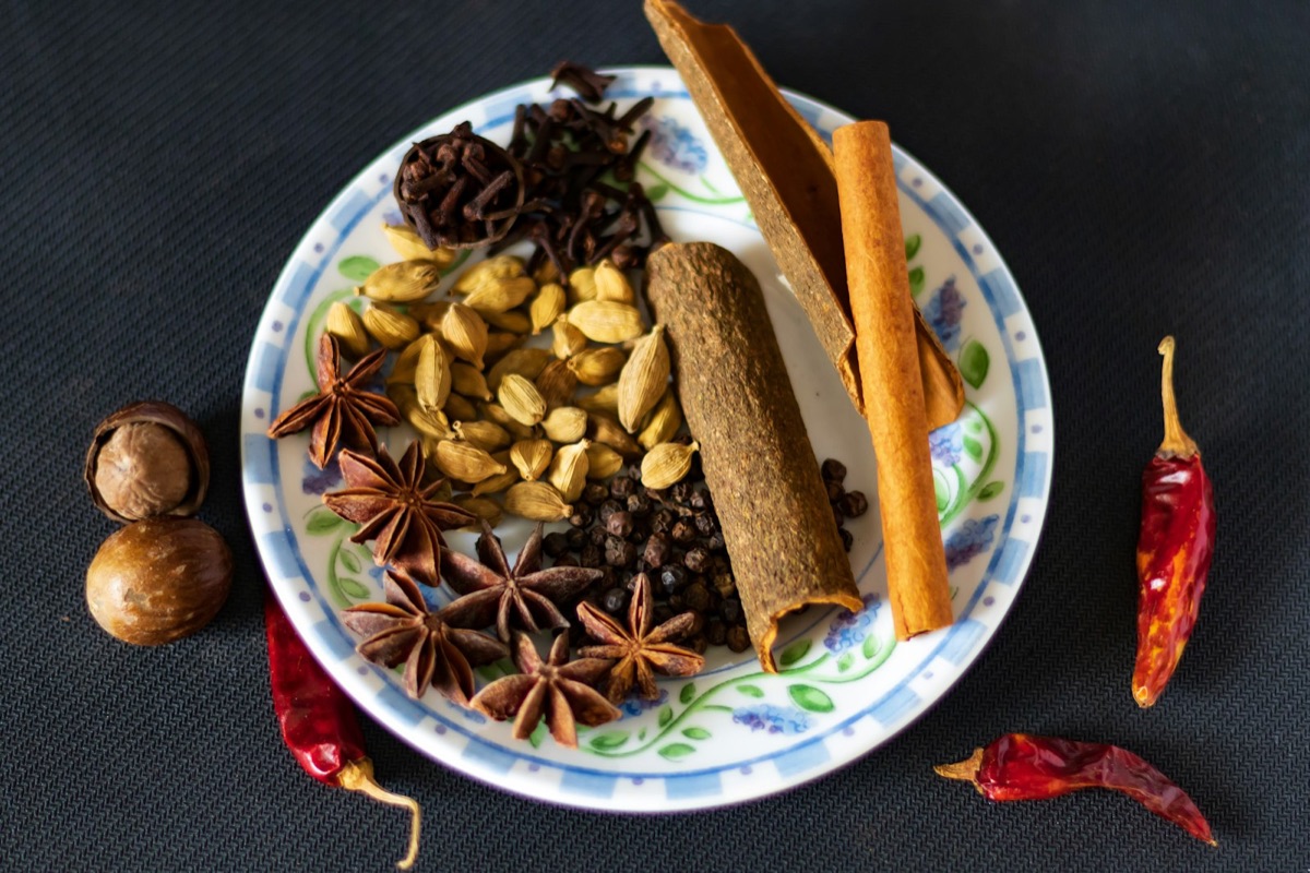 Bowls of Indian spices including turmeric, cardamom, and cloves