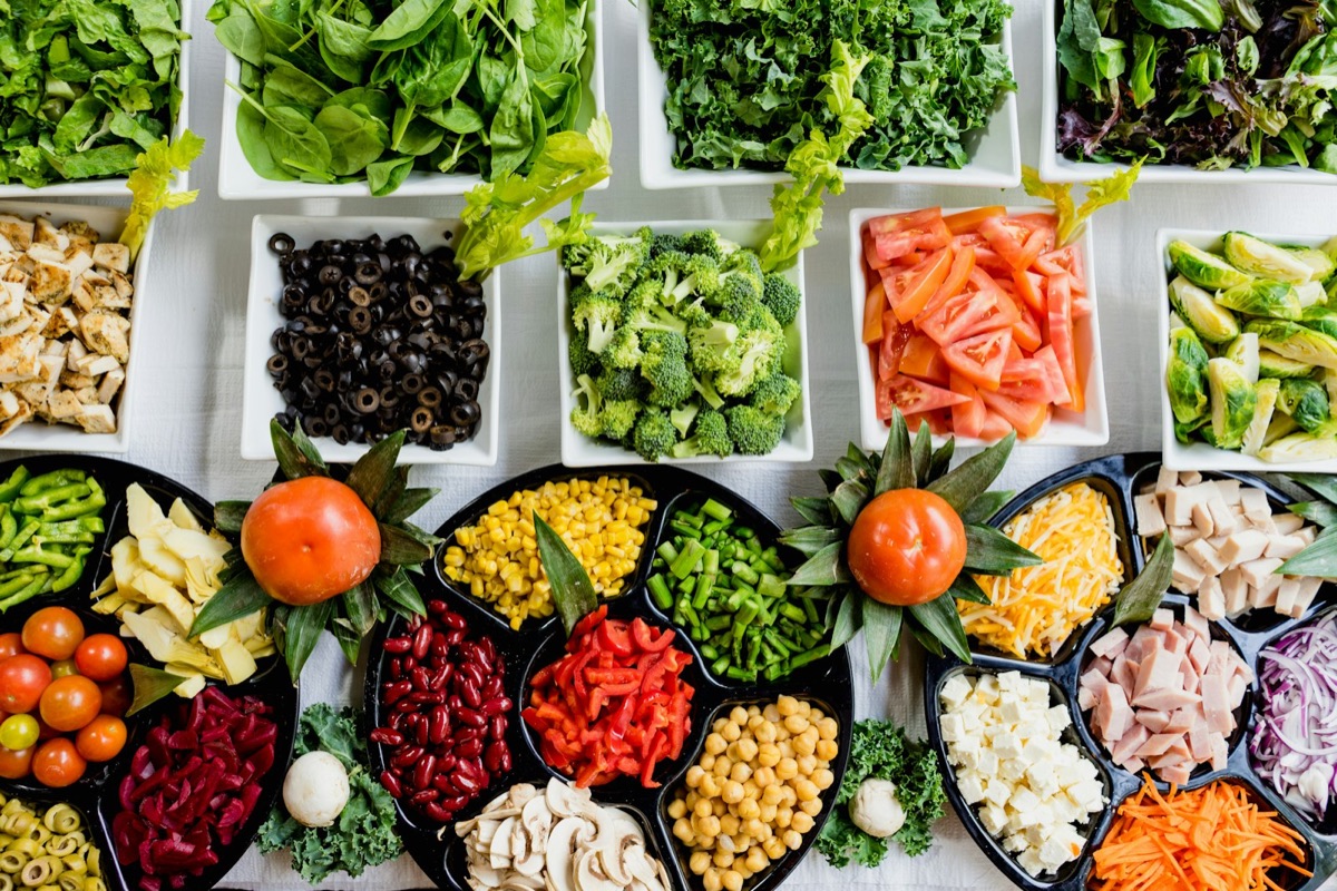Colorful array of fresh vegetables, proteins, and whole foods representing nutrient-dense eating